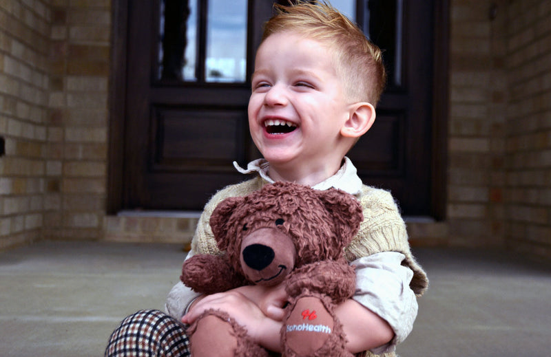 Custom Fair Trade teddy bear in arms of little boy